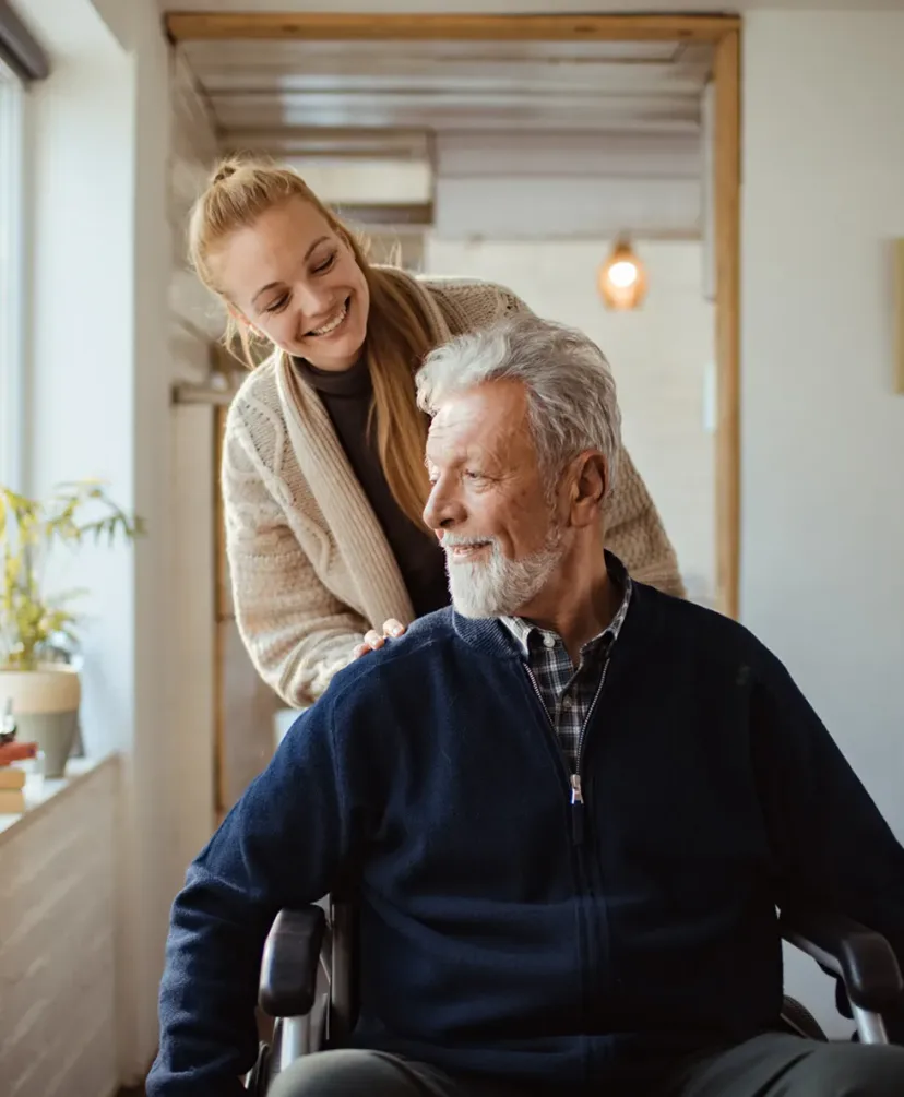 A carer talking with an older man at home.
